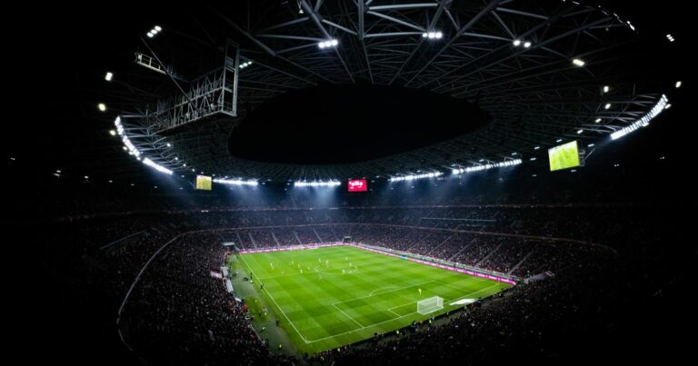 Stade de football en soirée, ambiance de Ligue Europa et Conference League